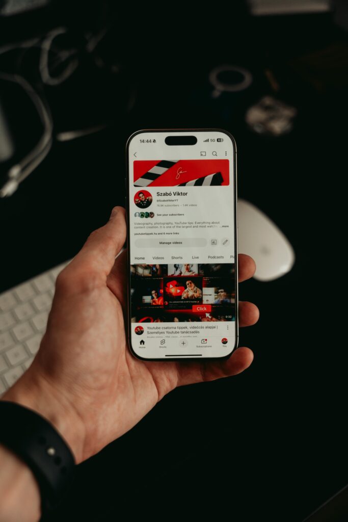 pexels-photo-32141317-32141317 A hand holding a smartphone displaying a mobile app interface with dark, modern visuals.
