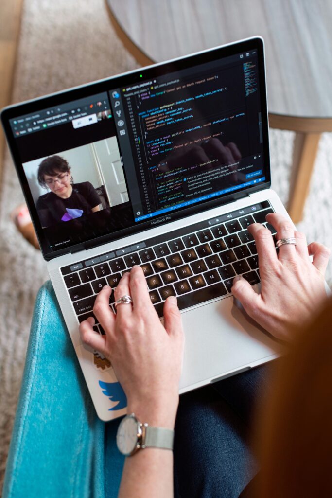 pexels-photo-3861964-3861964 Person coding on a laptop during a video conference, showcasing remote work.